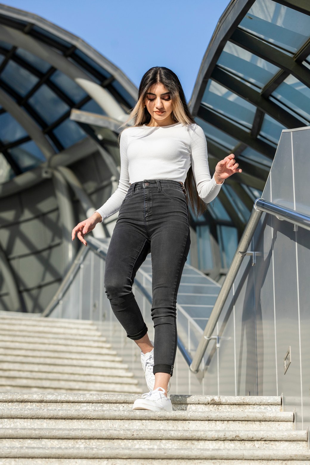 Vertical photo of young lady walking down on the stairs . High quality photo